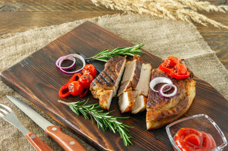 Fresh juicy roasted red meat on wooden board, with spices and vegetables. Restaurant food, delicious dishの写真素材