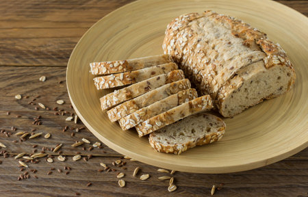 Gluten-free vegan bread with no animal products. Vegetarian bread with oatmeal, banana flavor on a plate on a wooden rustic table, sliced and ready to serveの写真素材
