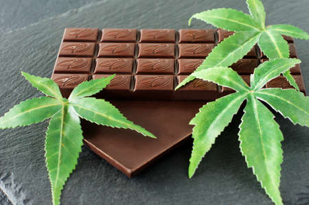 Marijuana leaves and dark chocolate on black background.の写真素材