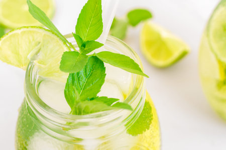 Lemon lemonade in mason jar glass made of fruit on a table background. Cold summer beverage. Mojito...