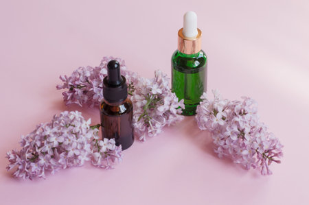 Skincare products - essential oil and serum - set with fresh lilac, closeup shot, lilac as background. Skincare and beauty conceptの写真素材