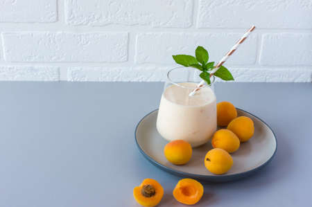 Apricot smoothie or yogurt and ripe apricots on a table. Delicious milk drink with ripe apricotsの写真素材