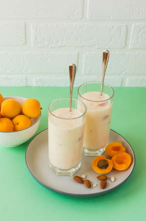 Homemade organic smoothie from yogurt and apricot. In high ball, on a table, with apricots.の写真素材