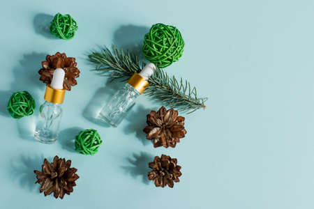 Essential oil of pine and spruce in small glass dropper bottles on a blue backgroundの写真素材