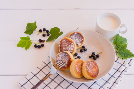 Homemade fried cheesecakes with milk and berries, close up.の写真素材