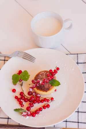 Cottage cheese pancakes, sweet curd fritters with red currant berries, syrniki on breakfast table.の写真素材