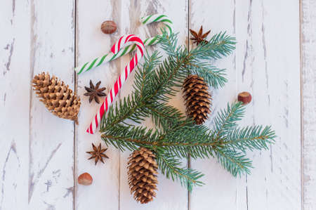 Christmas banckground with pine tree branches, cones and candy canes on rustic wooden boardsの写真素材