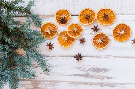 christmas festivw background with fir tree branches, dried oranges and anise stars on rustic wooden table. Top view with copy space.の写真素材