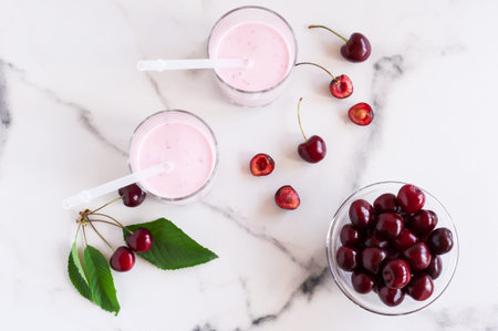 healthy organic food. cherry smoothie of ripe cherries in glass glasses on a marble background. top viewの写真素材