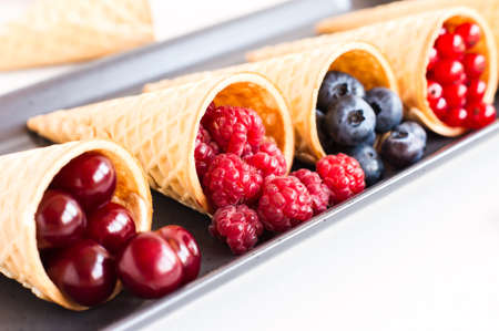 juicy berries of cherries, raspberries, blueberries, red currants in waffle cones. close angleの写真素材