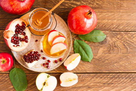 Rosh hashanah jewish new year holiday celebration concept. Honey, pomegranate and apples over wooden background. Top view.の写真素材
