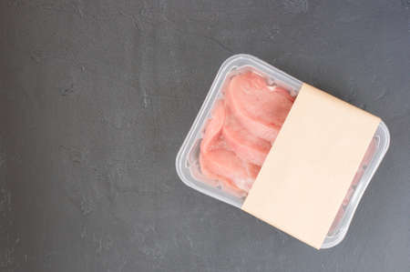 raw steak, entrecote in plastic vacuum packaging on a black background. logo layout designの写真素材