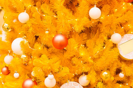 New Year's or Christmas background from a modern yellow tree with festive ballsの写真素材