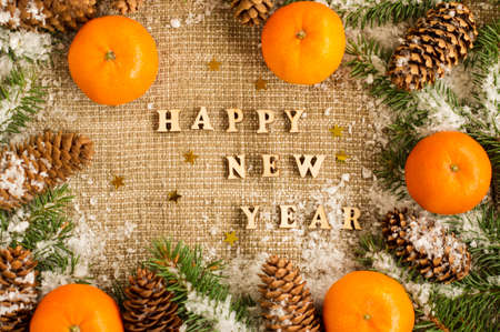 New Year's background with tangerines laid out on burlap, spruce branches and cones. rustic Russian styleの写真素材