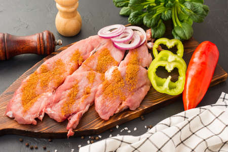 raw, steamed pork tenderloin ready to be cooked with spices and herbs on the cutting boardの写真素材