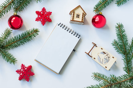 New Year's or Christmas background with spruce branches, red balls, wooden sleds and a toy house. top view. mockupの写真素材