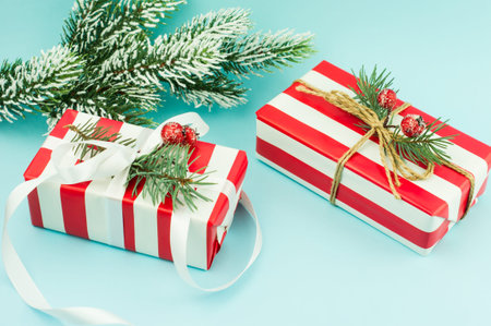 two festive New Year's packed boxes with gifts on a blue background. a branch was eaten in the snow....