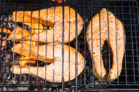 fresh salmon fish steaks on the grill. the concept of cooking on the street, backyardの写真素材