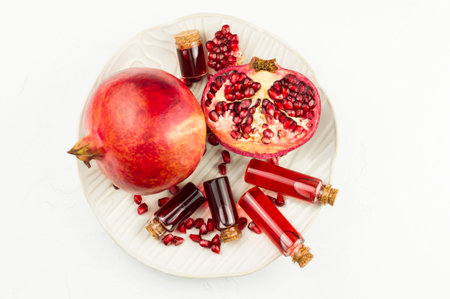 a large ceramic plate with bottles of cosmetics made of pomegranate seeds and pomegranate fruit. top...
