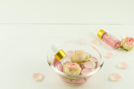 the concept of anti-aging care for the skin of the face. rose water, rose petal oil in cosmetic...