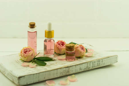 white wooden pouill with glass bottle with cork lid and pink essence, cosmetic bottle with rose oilの写真素材