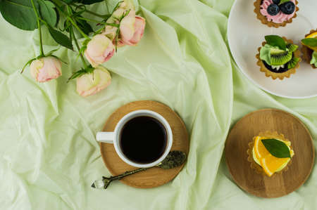 breakfast in the bed. a cup of coffee, mini tortillas with fruit and a bouquet of pink roses. the concept of celebrating Valentine's Day, 8 Marchの写真素材