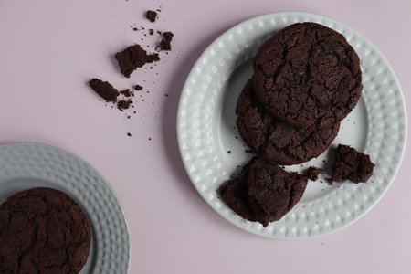 two plates with traditional homemade chocolate chip cookies, cookie pieces and crumbs. top view. pastel backgroundの写真素材