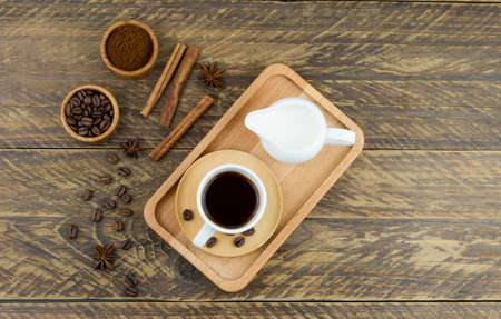 top view of the wooden tray with expresso cup, coffee assortment and milkman with milk. brown wood backgroundの写真素材