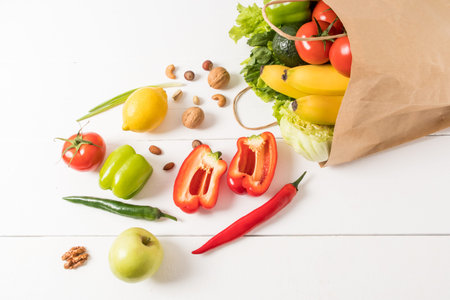 healthy vegan food in a craft paper bag on a white wooden background. the concept of the right...