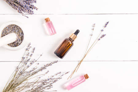 top view of the composition of several glass bottles with cosmetic products from lavana. organic cosmetics for body care. spa. white wooden backgroundの写真素材