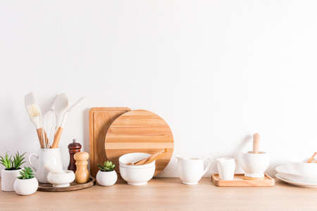various types of kitchen utensils on a wooden countertop at the textured white concrete wall. Zero waste,environmentally friendly conceptの写真素材