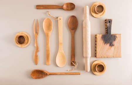 a set of various wooden spoons, cups and a cutting board on a light background. top view. flat styling. kitchen backgroundの写真素材