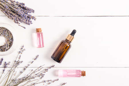 composition of natural cosmetic products of flowers and seeds of lavender. serum or oil in glass bottles on a white wooden background. top view.の写真素材