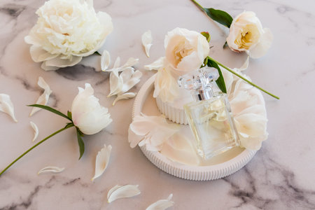 beautiful composition with a bottle of perfume with a floral aroma on a relief plaster plate...