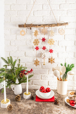 vertical view of a modern kitchen countertop decorated for the New Year and Christmas. homemade garland on a white brick wall.の写真素材