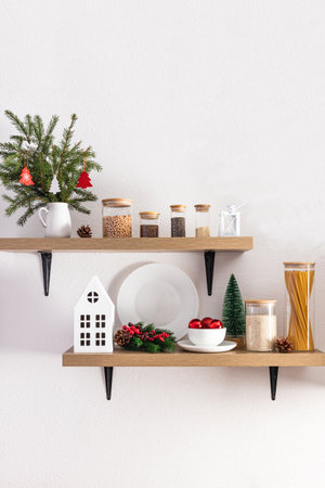 cozy comfortable interior design of open kitchen shelves decorated for the New Year and Christmas. foreground. white textured wallの写真素材