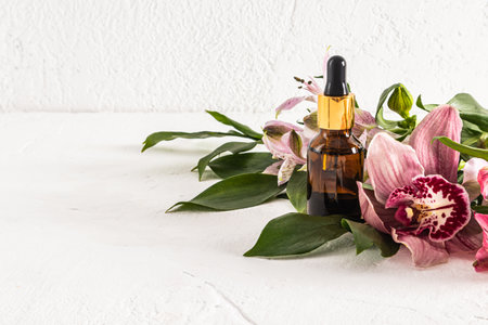 nature cosmetics in a glass bottle with a pipette and spring flowers on a light background. front view. space for text.の写真素材