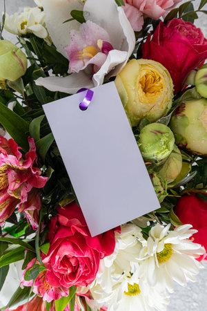 Vertical view of the bright beautiful part of the bouquet close-up with a blank white card for your...
