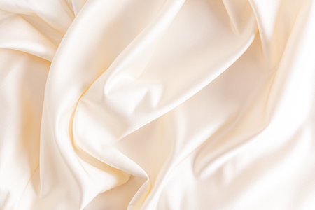 Luxurious satin fabric with delicate waves of beige color. wedding fabric background.の写真素材
