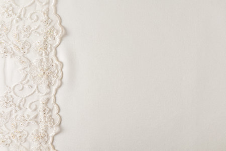 Ivory color background of satin fabric with bisher lace on one side. Border of the wedding background with a copy of the space. Design layoutの写真素材