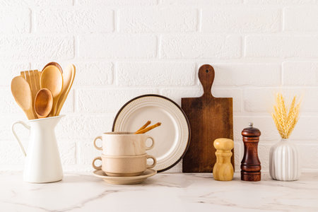Front view of a kitchen marble countertop with a set of kitchen utensils and utensils against a white brick wall. Cozy kitchenの写真素材