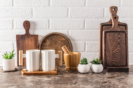 Eco-friendly utensils on a marble kitchen countertop in a stylish interior. A set of wooden dark...