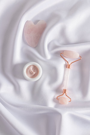 Rose Quartz Roller Massager, Gua Sha Cosmetic Scraper and Cream Jar for Home Care and Home Massage. Beauty concept.の写真素材