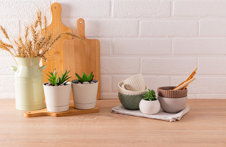 Light kitchen background with wooden eco-friendly kitchen utensils and pitcher with ears of corn. Modern kitchen space. Cozy homeの写真素材