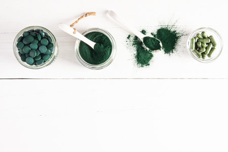 Natural Organic Spirulina Algae Powder, Tablets, Capsules in Glass Jars. Top view. border. Flat laying. A copy space. Organic food supplementsの写真素材