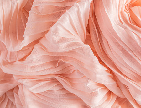 Soft air waves of peach-colored silk or chiffon fabric. Chic abstract festive background. Design mockup. Color of the Year 2024 Peach Fuzzの写真素材