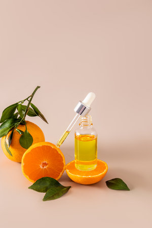 An open bottle with a cosmetic product for face and body skin care and a pipette filled with it against fresh tangerines. moisturizing serumの写真素材