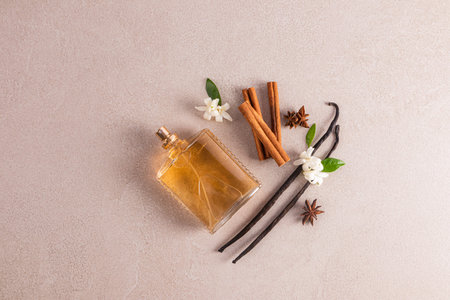 A transparent perfume bottle with an exquisite scent of cinnamon and vanilla on a beige background...