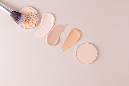Three swatches of liquid foundation powder, two blocks of compact powder, a chic brush for applying...
