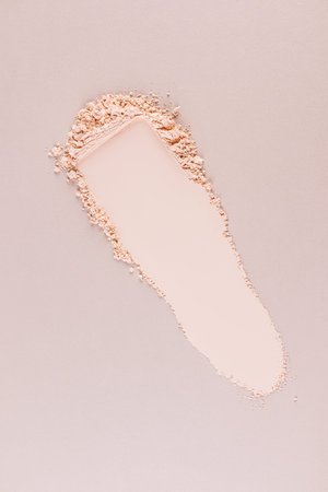 A beautiful swatch of natural loose powder for cosmetic facial skin care. Beige vertical background....
